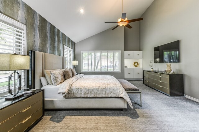 carpeted bedroom with ceiling fan, high vaulted ceiling, and multiple windows