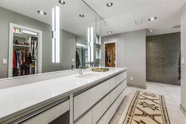 bathroom featuring tiled shower, vanity, and tile patterned floors