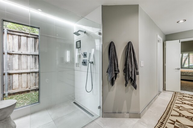 bathroom featuring tile patterned flooring and tiled shower