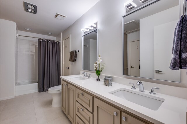 full bathroom featuring tile patterned floors, shower / tub combo with curtain, vanity, and toilet