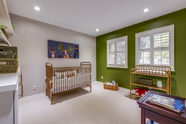 bedroom with carpet floors and a nursery area