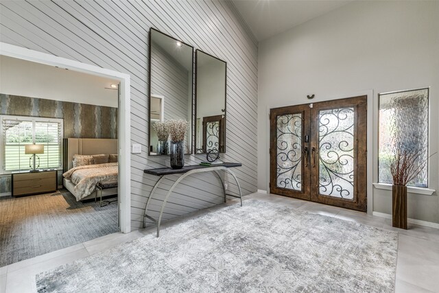 tiled foyer with french doors and high vaulted ceiling