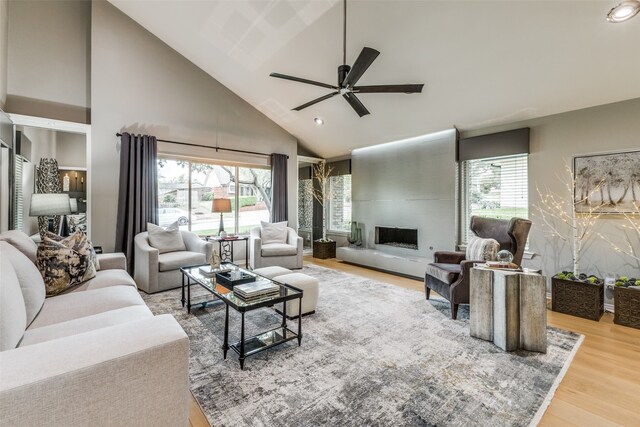 living room featuring a fireplace, plenty of natural light, high vaulted ceiling, and hardwood / wood-style flooring