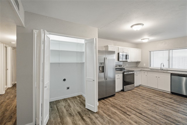 kitchen with white cabinets, sink, appliances with stainless steel finishes, and dark wood-type flooring