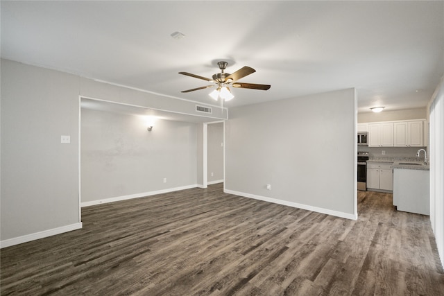 unfurnished living room with ceiling fan, dark hardwood / wood-style flooring, and sink