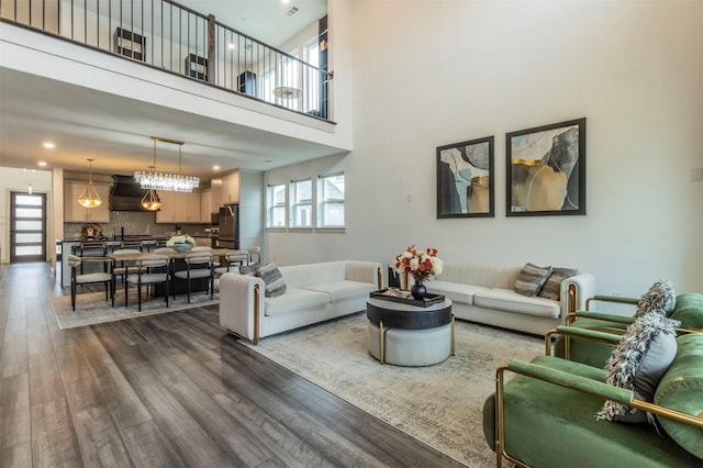 living room with a towering ceiling and wood-type flooring