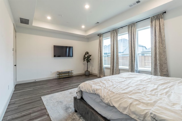 bedroom featuring dark hardwood / wood-style floors and a tray ceiling