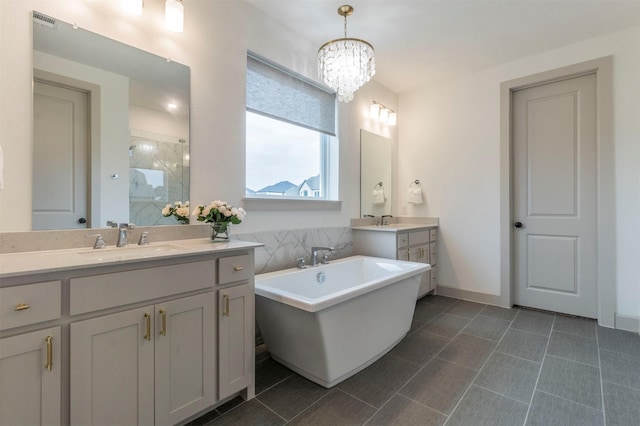 bathroom featuring shower with separate bathtub, vanity, and an inviting chandelier