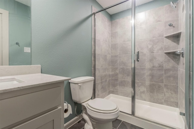 bathroom featuring tile patterned floors, a shower with door, vanity, and toilet