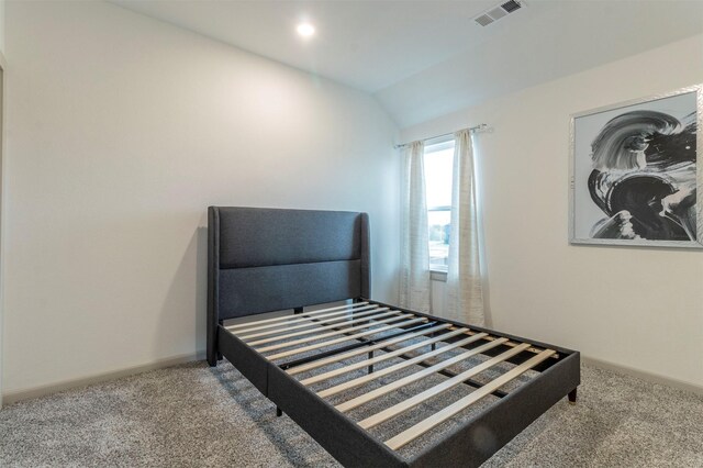 bedroom featuring carpet and vaulted ceiling