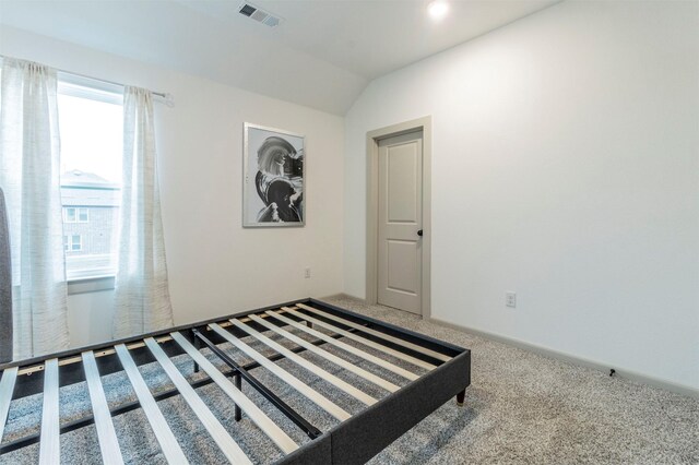 unfurnished bedroom featuring carpet and lofted ceiling