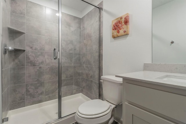 bathroom featuring an enclosed shower, vanity, and toilet