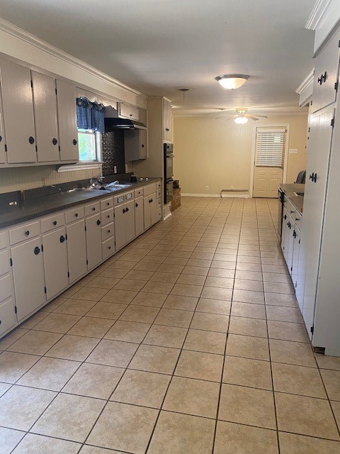 kitchen featuring ceiling fan, sink, double oven, decorative backsplash, and light tile patterned floors