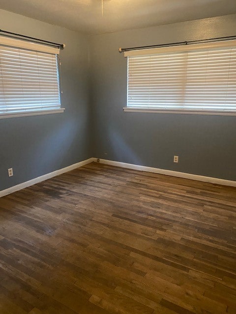 unfurnished room with plenty of natural light and dark hardwood / wood-style flooring