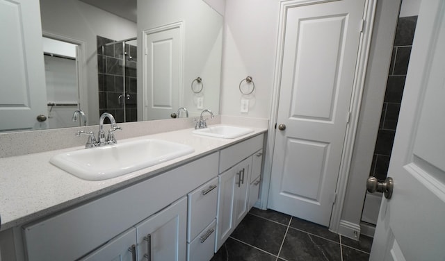 bathroom with tile patterned flooring, vanity, and tiled shower