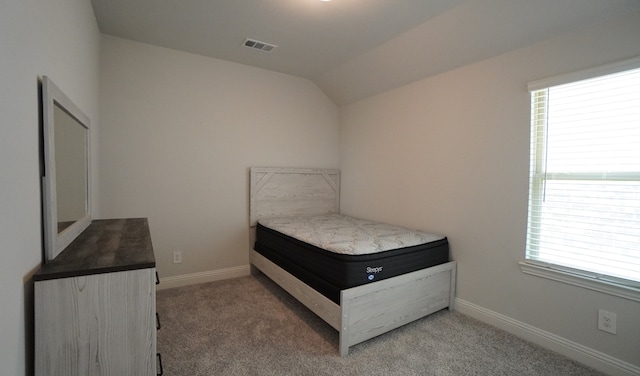 bedroom with carpet floors and lofted ceiling