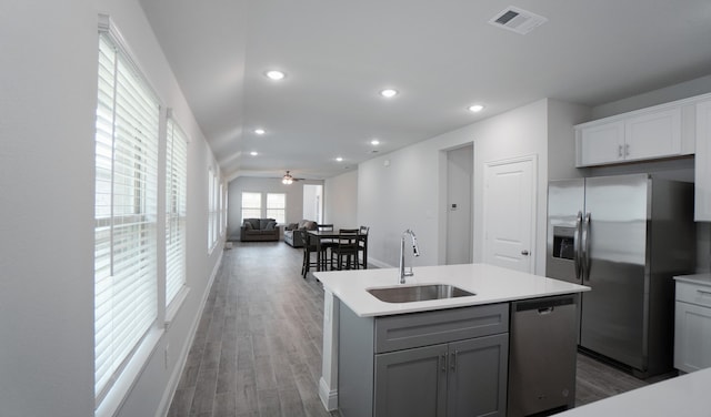 kitchen featuring ceiling fan, sink, stainless steel appliances, dark hardwood / wood-style flooring, and a center island with sink