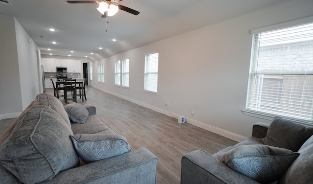 living room with ceiling fan, plenty of natural light, and light hardwood / wood-style floors