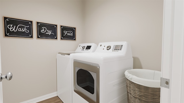 laundry room with hardwood / wood-style floors and washer and dryer