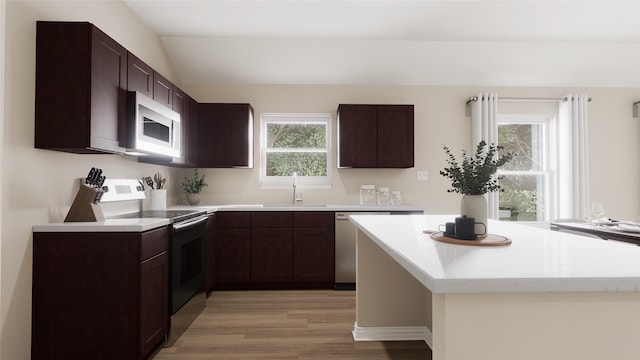 kitchen featuring a wealth of natural light, sink, light hardwood / wood-style floors, and electric range oven