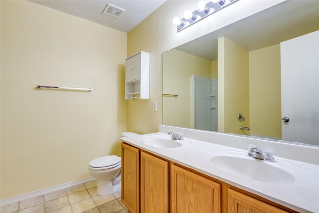 bathroom featuring vanity, toilet, and a shower with shower door