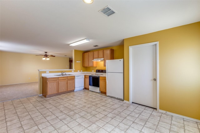 kitchen featuring kitchen peninsula, white appliances, light colored carpet, ceiling fan, and sink