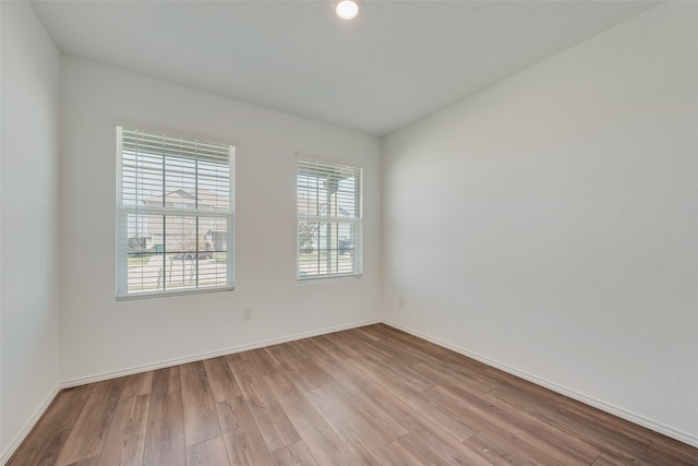 empty room with plenty of natural light and light hardwood / wood-style floors