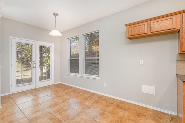 unfurnished dining area with french doors and light tile patterned flooring