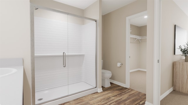 bathroom featuring hardwood / wood-style floors, toilet, and walk in shower