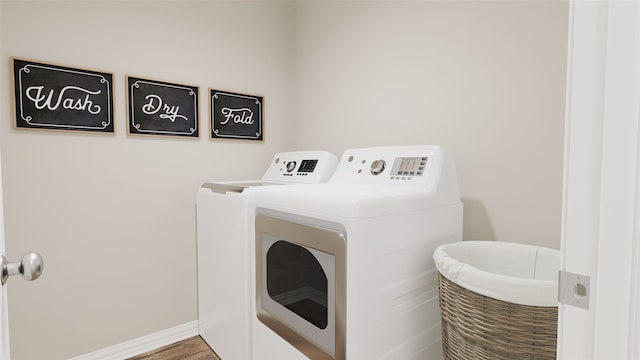 washroom featuring washing machine and clothes dryer and hardwood / wood-style floors