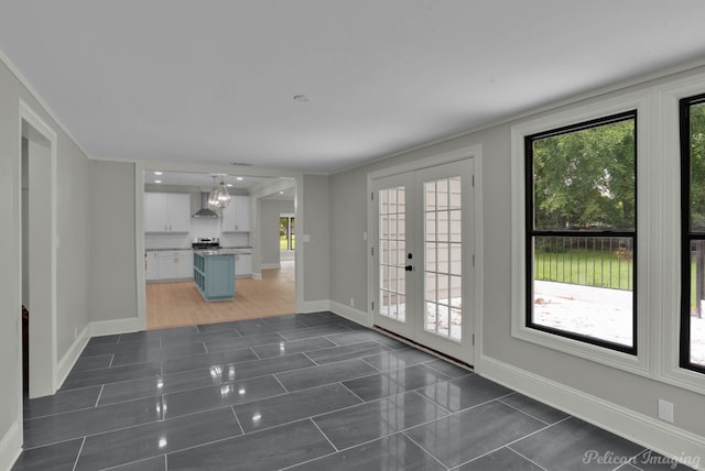 interior space featuring dark tile patterned floors, ornamental molding, and french doors