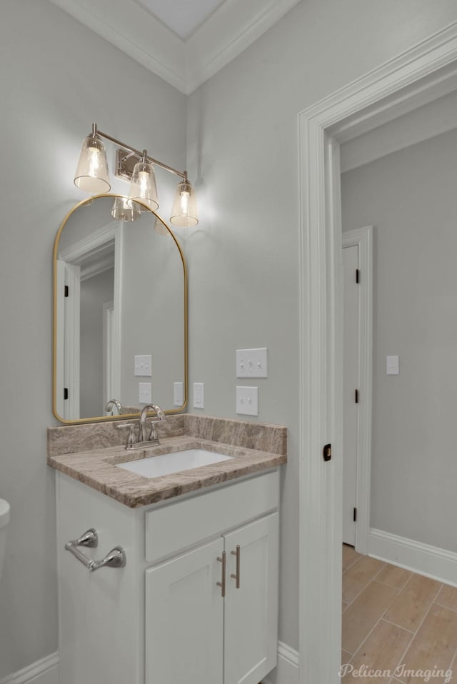 bathroom featuring hardwood / wood-style flooring, vanity, and ornamental molding