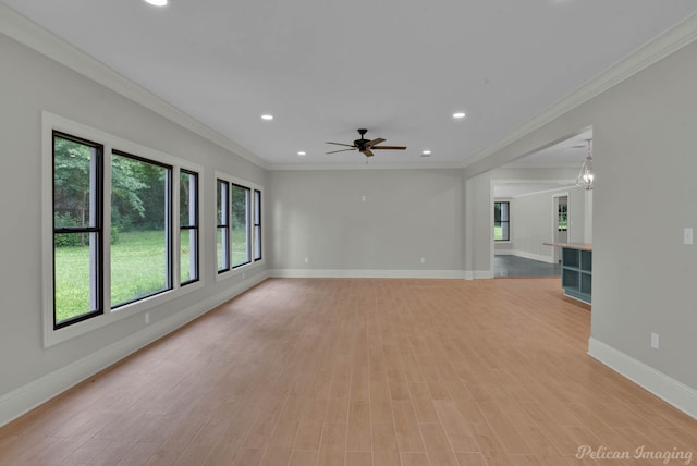 spare room featuring light hardwood / wood-style floors, a wealth of natural light, and ornamental molding