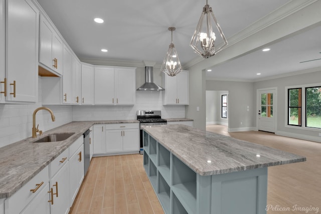 kitchen featuring light stone countertops, a center island, wall chimney range hood, white cabinets, and appliances with stainless steel finishes