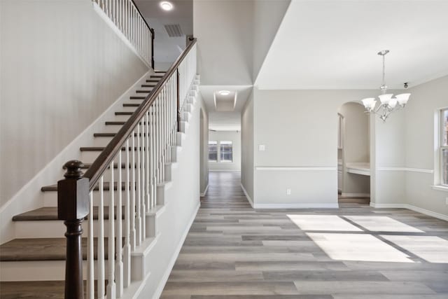 stairway featuring hardwood / wood-style floors, a healthy amount of sunlight, and crown molding