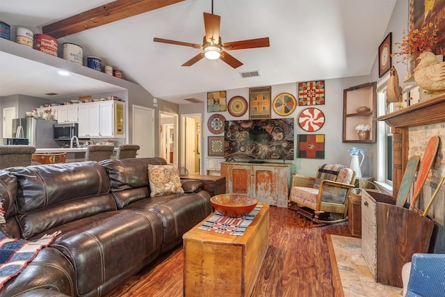 living room featuring a fireplace, light hardwood / wood-style flooring, lofted ceiling with beams, and ceiling fan