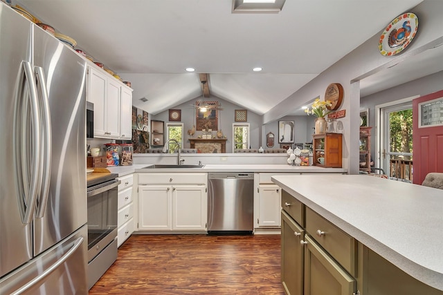 kitchen with a healthy amount of sunlight, appliances with stainless steel finishes, kitchen peninsula, and sink