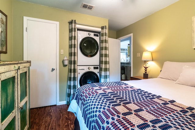 bedroom with stacked washing maching and dryer and dark hardwood / wood-style flooring