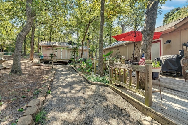 view of yard featuring a storage shed and a wooden deck