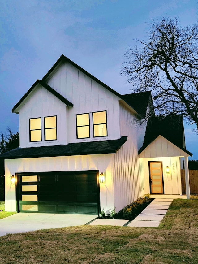 modern farmhouse featuring a front yard and a garage