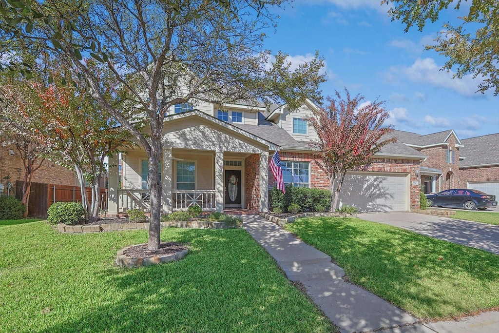 view of front of house with a garage, a front yard, and a porch