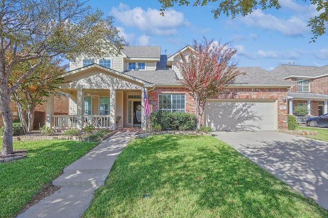 view of front of home featuring covered porch, a garage, and a front lawn