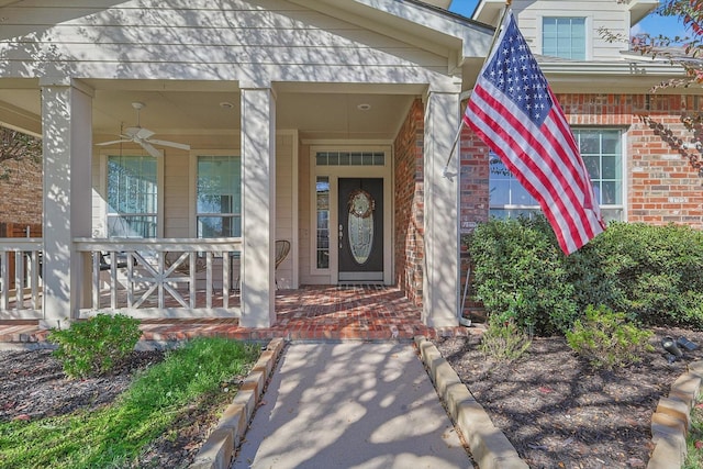 view of exterior entry featuring a porch and ceiling fan