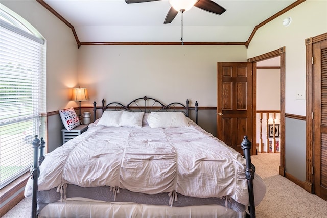 bedroom with ceiling fan, ornamental molding, carpet flooring, and vaulted ceiling