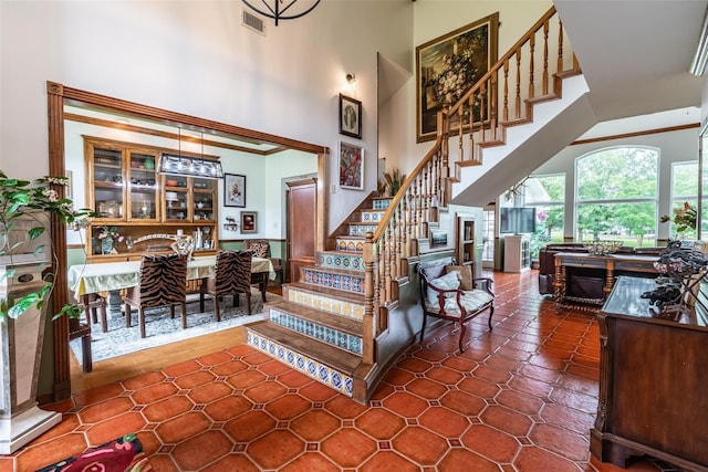 staircase with tile patterned flooring and a high ceiling