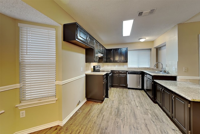 kitchen featuring appliances with stainless steel finishes, dark brown cabinets, a textured ceiling, sink, and light hardwood / wood-style flooring