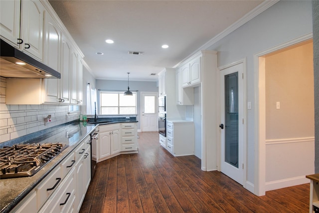 kitchen with dark wood-type flooring, stainless steel appliances, ornamental molding, white cabinets, and decorative light fixtures