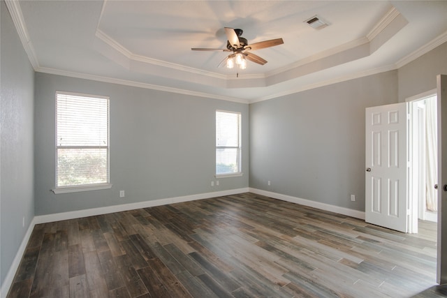 unfurnished room featuring dark hardwood / wood-style flooring, a tray ceiling, ornamental molding, and ceiling fan