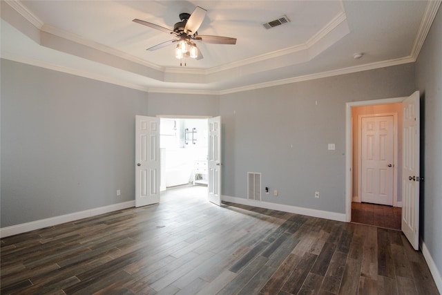 spare room featuring ornamental molding, dark wood-type flooring, ceiling fan, and a tray ceiling