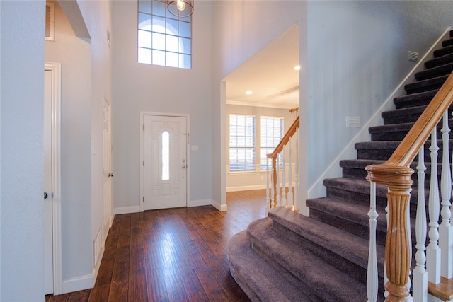 entrance foyer featuring a high ceiling, dark hardwood / wood-style floors, and ornamental molding